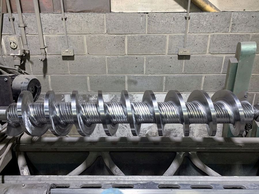 Extruder screw with machined flights set up on a lathe in the TWS workshop